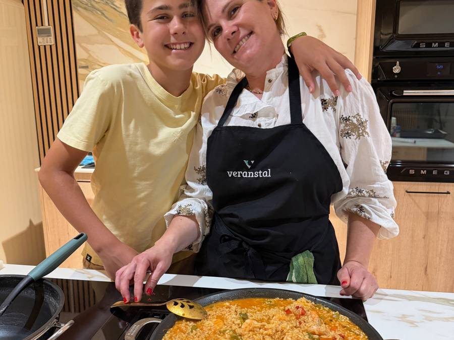 Madre e hijo con delantal Veranstal junto a la paella que han cocinado